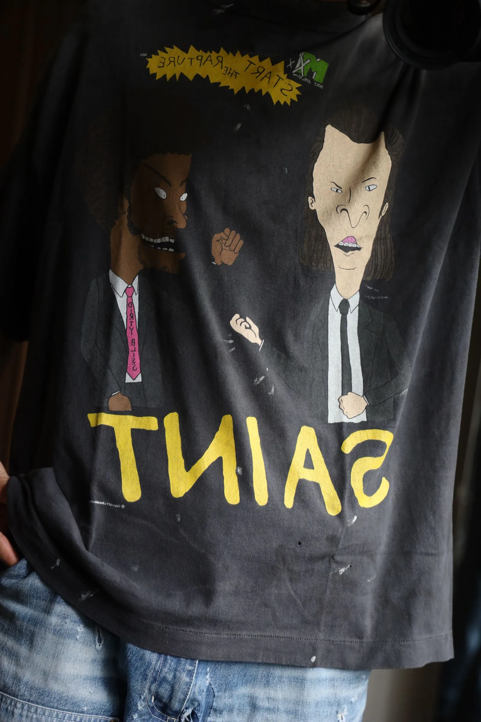 SAINT Mxxxxxx RAPTURE SS TEE/BLK Beavis and Butt-Head anime character TEE. Washed black S-XL. The print is from the characters of the American classic animation "Beavis and Butt-Head". It also pays tribute to the two classic killer characters in "Pulp Fiction". It is very witty and humorous. The whole garment is washed again.